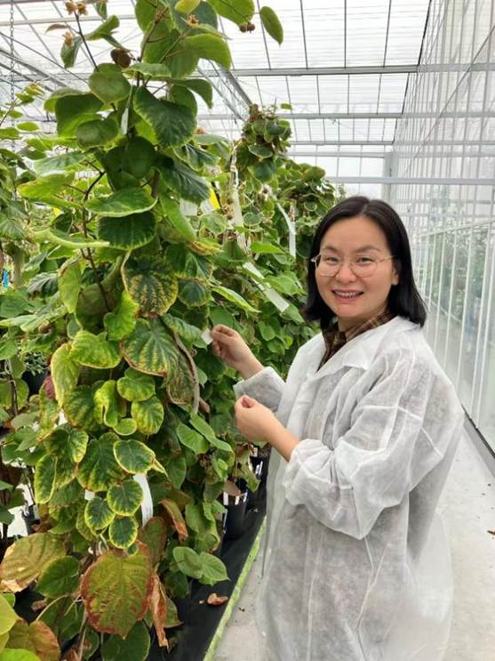 女人站在树下 中度可信度描述已自动生成